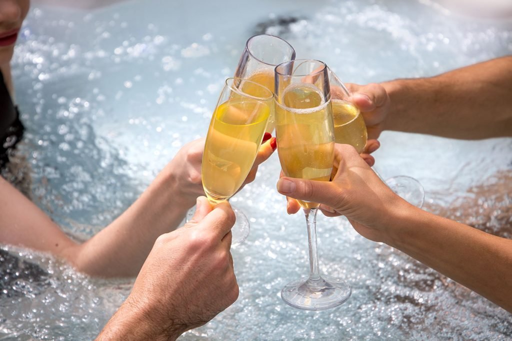 a group of people clinking glasses in a hot tub